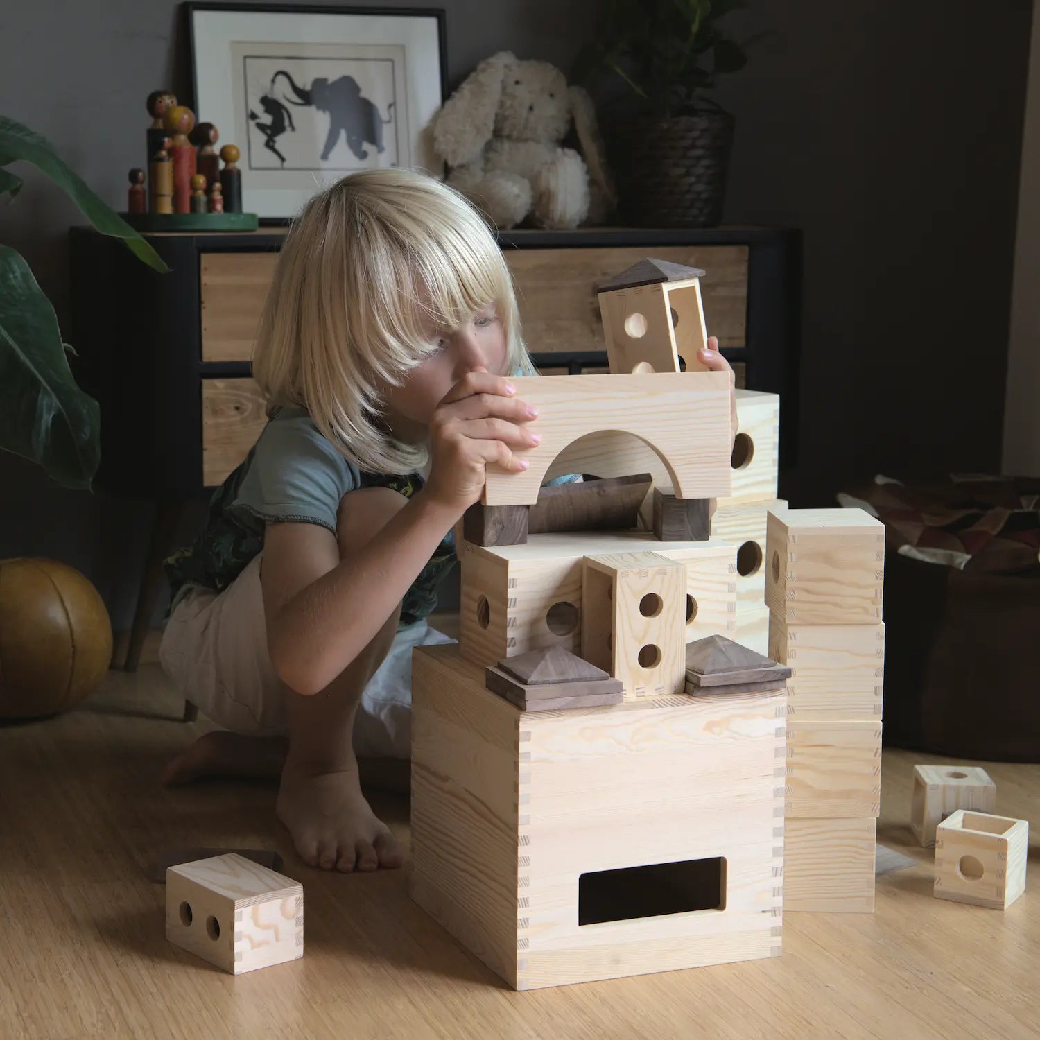 Ein Kind baut fokussiert mit dem Kreativbaukasten einen Turm